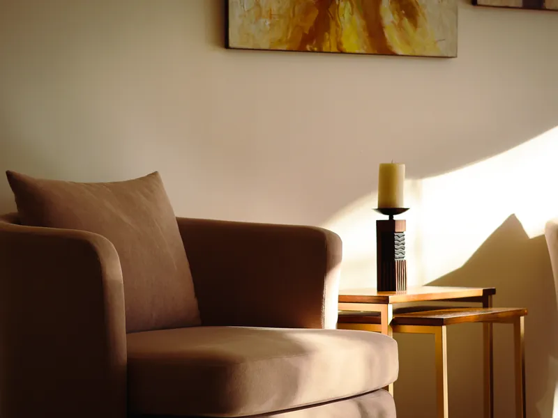 Sillón junto a la luz natural en una consulta de psicología acogedora