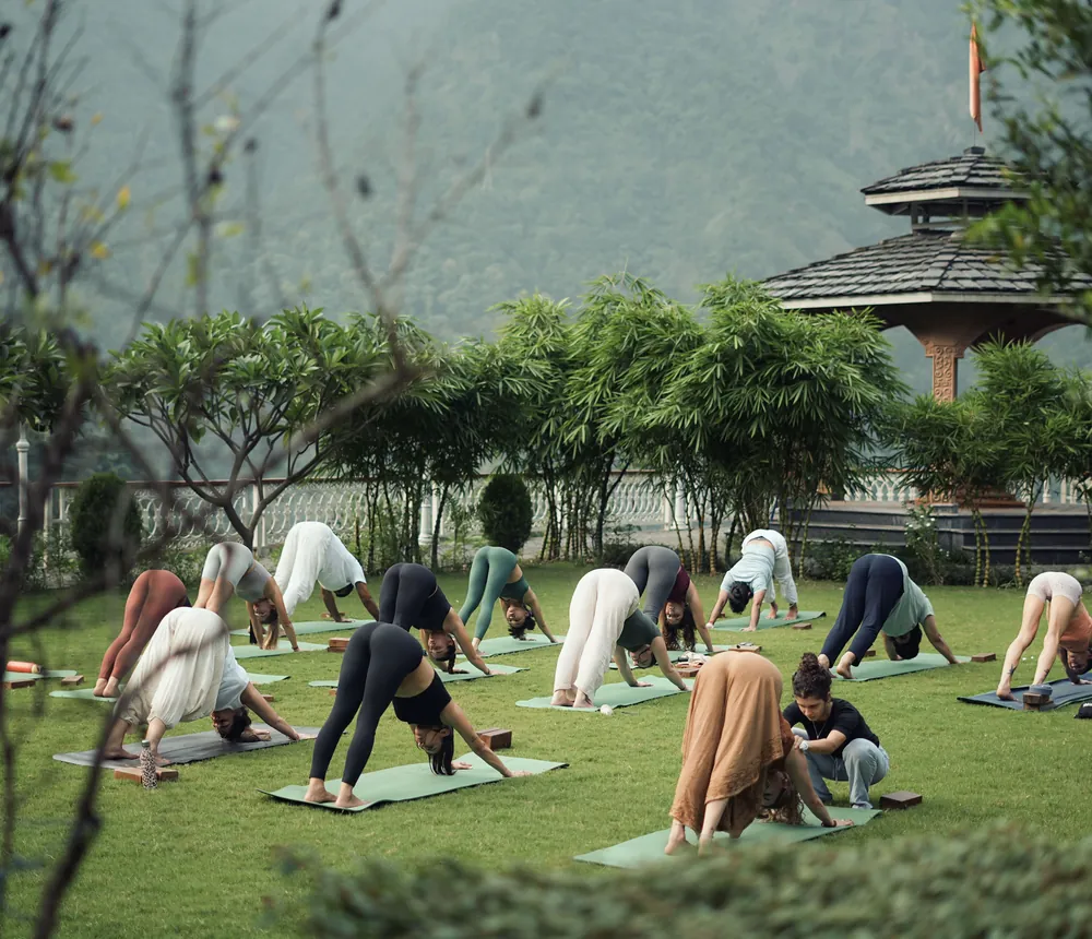 Grupo practicando yoga al aire libre durante un retiro de bienestar