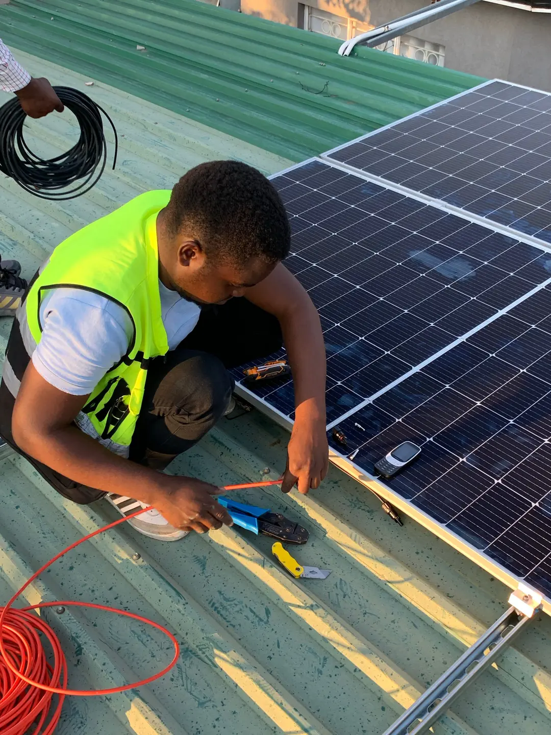 Instalador montando placas solares fotovoltaicas sobre un tejado