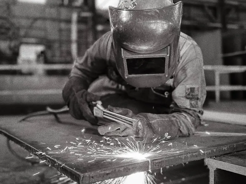 Soldador trabajando el metal en una fábrica del sector industrial