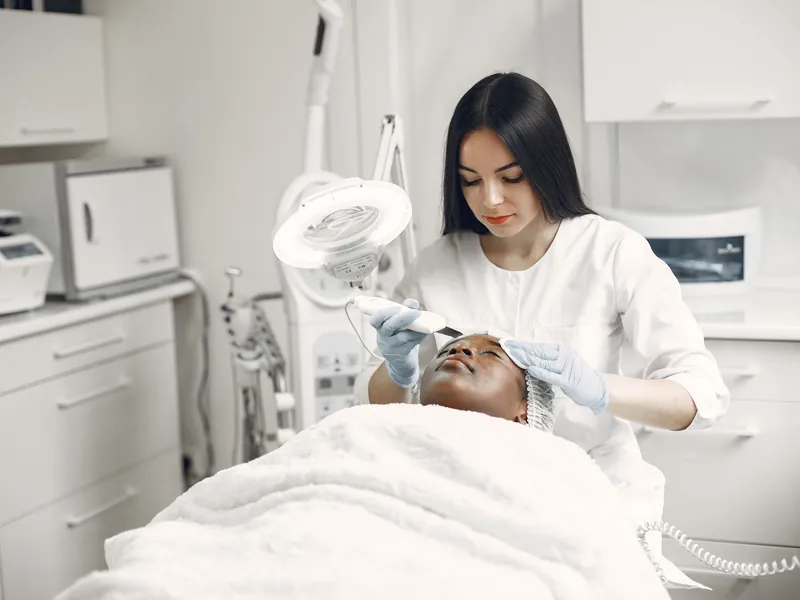 Esteticista aplicando un tratamiento facial en una clínica estética